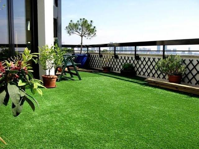 Terraza de piso con césped artificial y mobiliario exterior