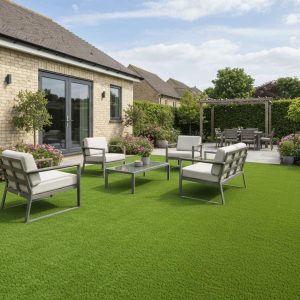 Proveedor de césped artificial: jardín con césped artificial y una zona de sillones junto a la casa